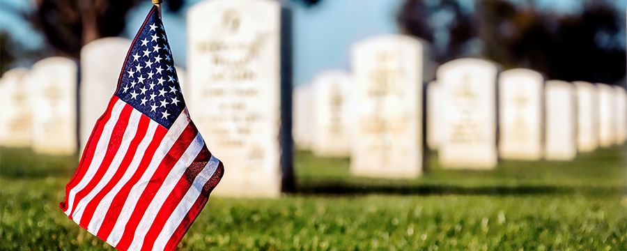 flag in front of military headstones
